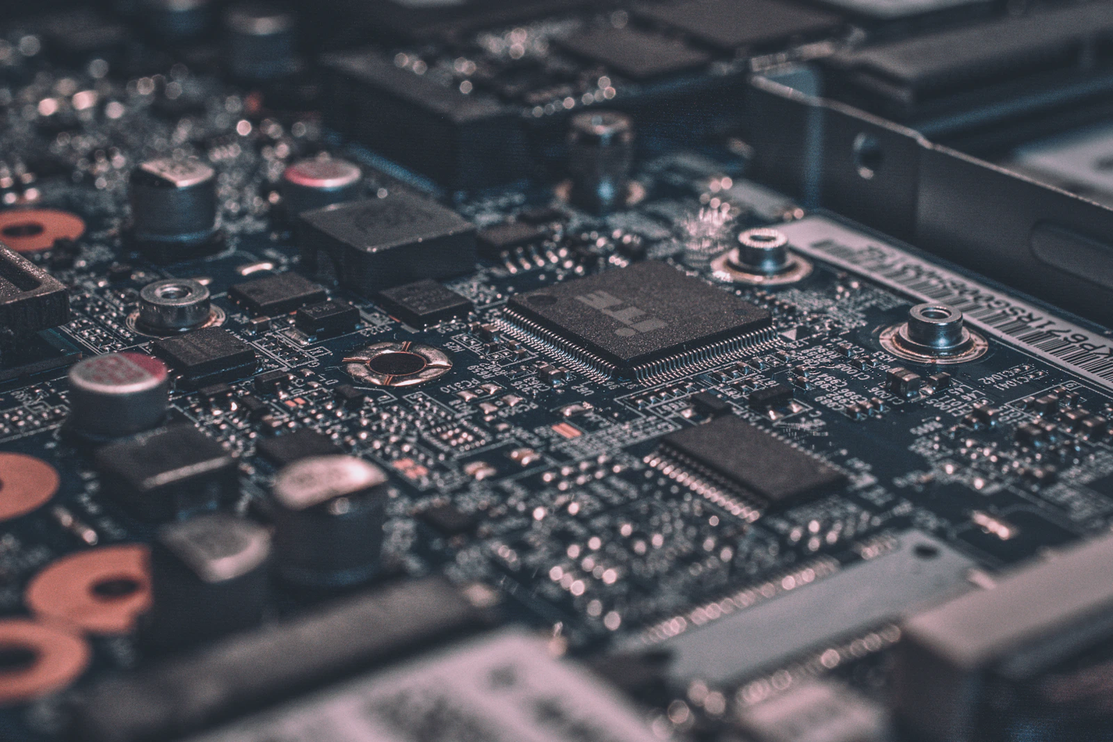 Placa de circuito eletrônico em detalhe, com trilhas e componentes iluminados